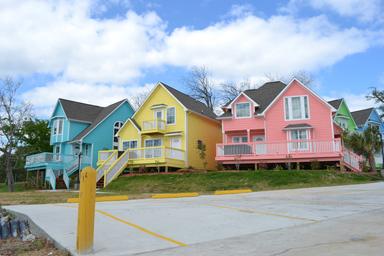 Row of colorful waterfront cottages shown from ground level — useful to show cabin/accommodation options on the property (from the site’s About page).