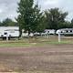 a row of rvs are parked in gravel sites
