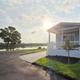 Front exterior of a cottage home with river in the background at sunset; highlights available homes/cottages and the waterfront setting (used on the resort page as a river-view home image).
