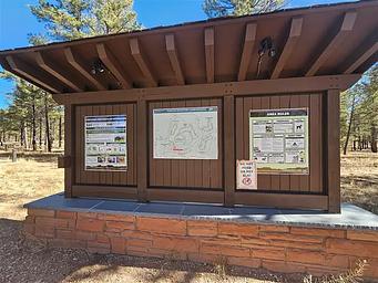 A three-panel information kiosk with a campground map on the center panel.