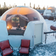Aerial/close overview of an on-site igloo with decking and interior visible; clearly shows the property’s unique accommodation layout and furnishings (page: Igloos - Borealis Basecamp).