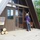 A person standing at Twin Lakes Cabin entrance next to a bear box