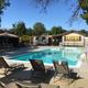 Swimming pool area with lounge chairs and surrounding amenities — depicts a major on-site recreation facility listed for the campground.