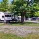 Panoramic shot of multiple RV sites and picnic tables along a gravel roadway — clear view of RV pitch layout and site amenities.