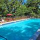 Outdoor swimming pool with deck chairs and fencing — clearly a campground amenity. Image is from the site Home page (ic‑home2.jpg), confirming it’s on the property.