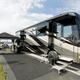 On-site RV pitch with a large motorhome, awning, outdoor mat and patio setup — demonstrates typical RV site size and setup at the resort (used on the property gallery).
