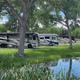 Pull-in RV sites shown on grass with a small pond/landscaping in foreground — matches images on the 'Ways to stay' pages and highlights level pull-in sites and scenery.