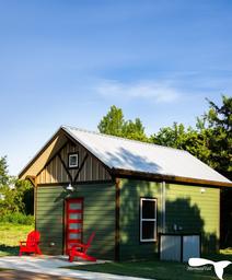 Cabin exterior with porch chairs and surrounding greenery — represents the resort's cabin accommodations. Image appears on the site's cabins/accommodations content.