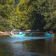 Scenic river image with people tubing on floats showcasing the resort’s river recreation; used on the homepage/river trip content.