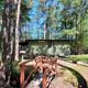 Cabin exterior with small footbridge and picnic table beside a creek/pond — good view of cabin lodging and grounds. Sourced from the site’s campground/cabin photos.