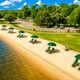 Aerial/angled view of the park’s sandy beach with lounge chairs and umbrellas along the lakeshore — clearly shows the on-site beach area from the property homepage (https://lakeendpark.net/).