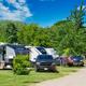 Row of RV sites with vehicles and hookups along a campground road, showing site setup and spacing — supports ‘Sites & RVing’ section imagery.