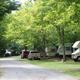 Row of RV sites along a tree-lined road with parked motorhomes — clearly shows the campground's RV pitches and layout; sourced from the lodging & campsites section.