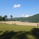 A sandy beach at a mountain lake on a blue sky day