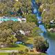 Aerial overview showing the resort layout: pool, lakes, bridge, and surrounding RV/cabin areas — useful for a property gallery and matches the Bulow RV Resort page context.