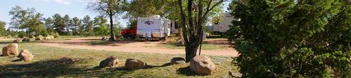 Close ground-level view showing RVs, grassy campsite loops and shade trees — good depiction of typical RV pitches and site spacing; from the 'Campground Video' page.