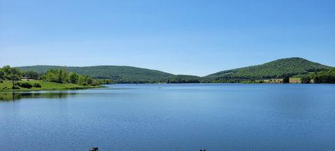 Wide panoramic lake view across a large body of water and surrounding hills — strong scenic overview consistent with the campground’s waterfront setting on the site.