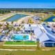 High-resolution aerial view showing the resort layout: clubhouse, pool, surrounding lakes and RV pads — strong overview of property (source: site gallery aerial image).