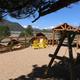 Outdoor seating area and play-structure with Adirondack chairs and distant mountain/snow-capped peaks — shows campground guest areas and the scenic views advertised on the property page.