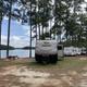 Row of RVs/campsites along the shoreline with picnic table and water visible—shows campsite/RV pitch area (Split Oaks campground section).