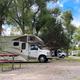 RV campsite row with motorhome, picnic table and mature trees — clear representation of the RV camping area and site setup (from reservation/tent camping page).