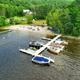 Close aerial view of the docks and sandy beach with boats and swimmers — useful for showing waterfront amenities (site photo showing dock/beach).