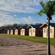 Row of on-site cabins along a sandy beach/shoreline — good interior lodging view (from the Cabins page).