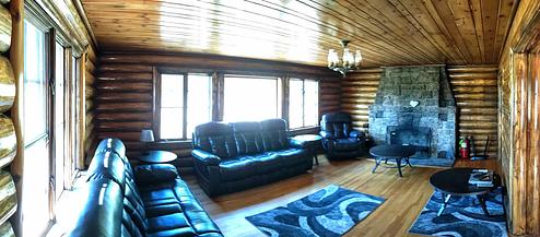 Redfeather Ranger Cabin: Living room showing stone fireplace, two couches, a chair, and rugs. 