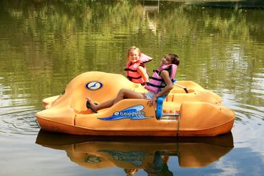 Paddleboat with children on a calm lake — demonstrates another on-site water activity (paddleboats) visible in site imagery.