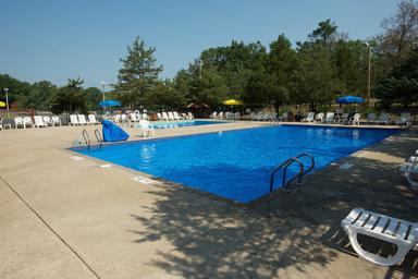 Large outdoor swimming pool with deck chairs and umbrellas — prominent facility shown on the Arrowhead RV Resort page and suitable for the property gallery (banner-style photo on the listing).