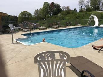 Clear photograph of the outdoor swimming pool and deck seating (from the homepage) — shows on-site pool facility available to guests.