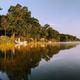 Wide lakeshore panorama showing the lake edge, trees and small docks/boats — good scenic overview of the waterfront setting on the property.