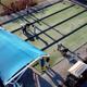 Aerial/drone view of bocce/ lawn bowling courts with players and covered seating — provides an overview of recreation facilities and layout.