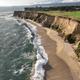 Aerial/cliff coastline view showing beachfront and nearby buildings (used as the site’s main share image on the homepage) — good overview of the park’s coastal setting and proximity to the beach.