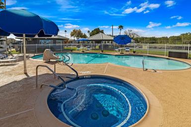 Clear pool and spa photo on the resort banner—shows on-site heated pool and hot tub with fencing and umbrellas, consistent with property amenities on the Lakewood RV Resort page.