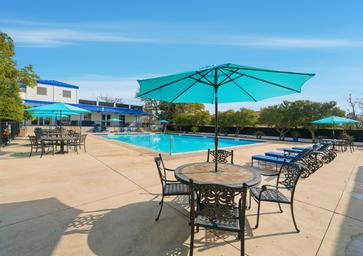 Clear daytime photograph of the resort’s swimming pool, deck seating and surrounding amenity area — matches the amenities listed on the property page.