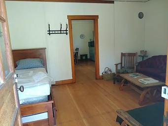 A living room with a bed, couch, futon, and table.