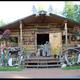Log cabin storefront with outdoor decorations, moose antlers and planters — clear photo of the Tatlanika gift shop/building shown on the site, useful as a facility shot for the campground/gallery.