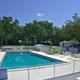 Clear, wide shot of the swimming pool with surrounding deck and RVs/trees in background — showcases on-site pool amenity (gallery page).