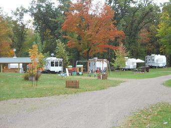 Wide shot showing multiple RV sites, playground equipment and campground road — useful for illustrating site spacing and amenities (gallery image).