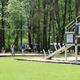 Playground area with swings and play structure on maintained lawn — matches amenities (playground) listed on the campground’s amenities page.