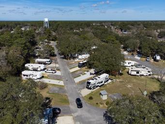 Aerial view showing campsites with RVs and nearby water tower landmark — useful for location/context and overall grounds; from the site's drone gallery.