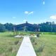 Covered picnic pavilion set in open lawn with a pond/landscape beyond — shows scenic grounds and a park amenity consistent with the property description.