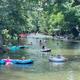 River scene with people floating and trees along the bank — depicts the on-property river/recreation (file labeled river-float on the campground site).