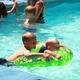 Outdoor heated pool with children playing — shows the campground’s pool amenity referenced in the recreation/activities section of the site.