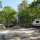 View down a campsite road flanked by RVs and trees — good overall view of RV site layout and wooded campground environment (appears on the campground's listing).