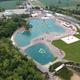 Large aerial of the resort’s water features and surrounding facilities — shows the main lagoon-style swim/waterpark and adjacent buildings matching the property’s amenities imagery (aerial-view.jpg).