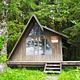 Mallard Slough Cabin exterior brown cabin with slanted roof with trees surrounding it