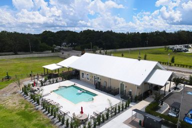 Aerial view of the clubhouse and swimming pool area, clearly showing the pool, deck, fencing and building — highlights on-site amenities (source: Portfolio page).