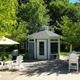 Ground-level photo of a gazebo seating area with landscaping and chairs — good depiction of campground amenity and outdoor common space from the 'Rent A Premium Site' content.
